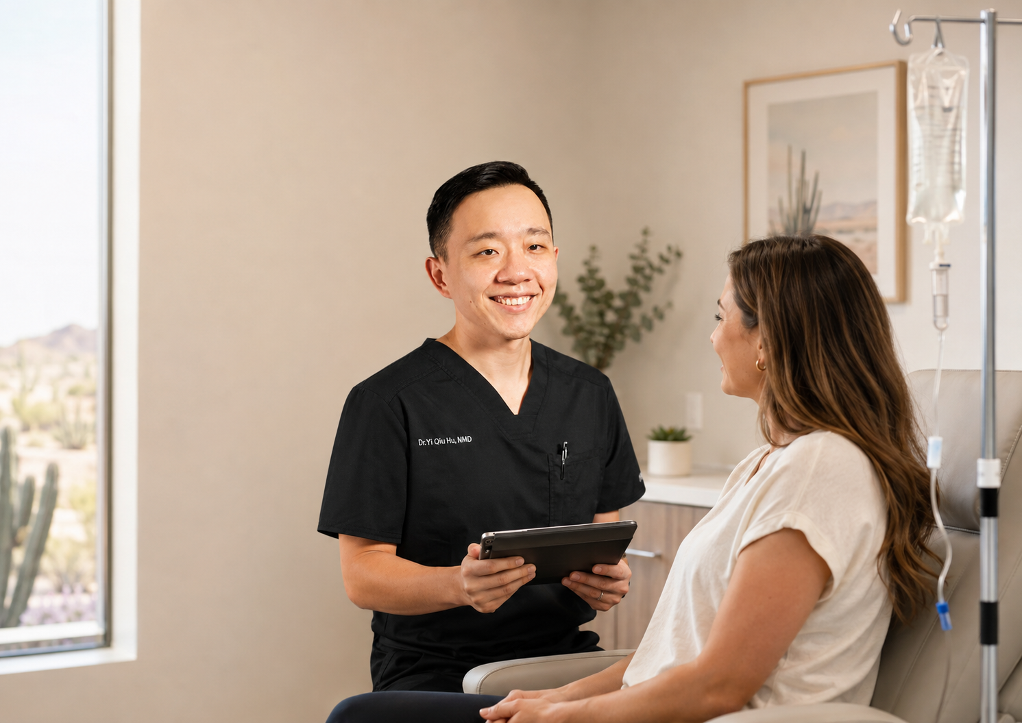 Dr. YiQiu Hu discussing IV therapy preparation with a patient in Arizona