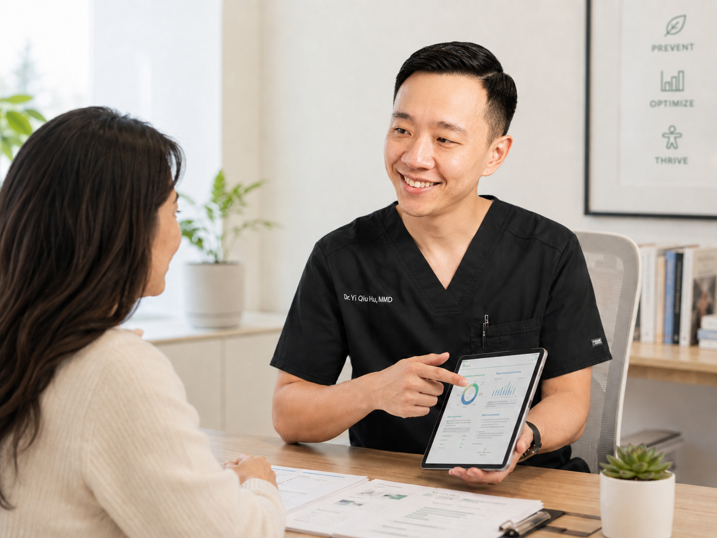 Dr. Hu reviewing preventive screening results and a personalized health optimization plan with a patient