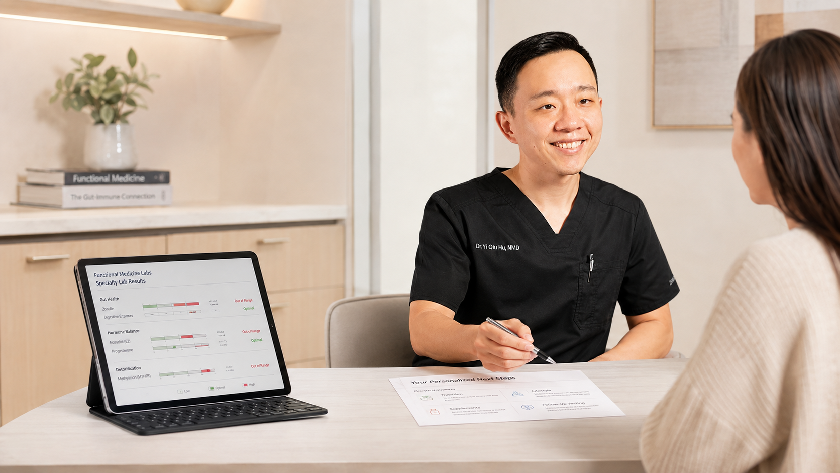 Medical professional in black scrubs talking to a woman at a desk with a tablet showing lab results.