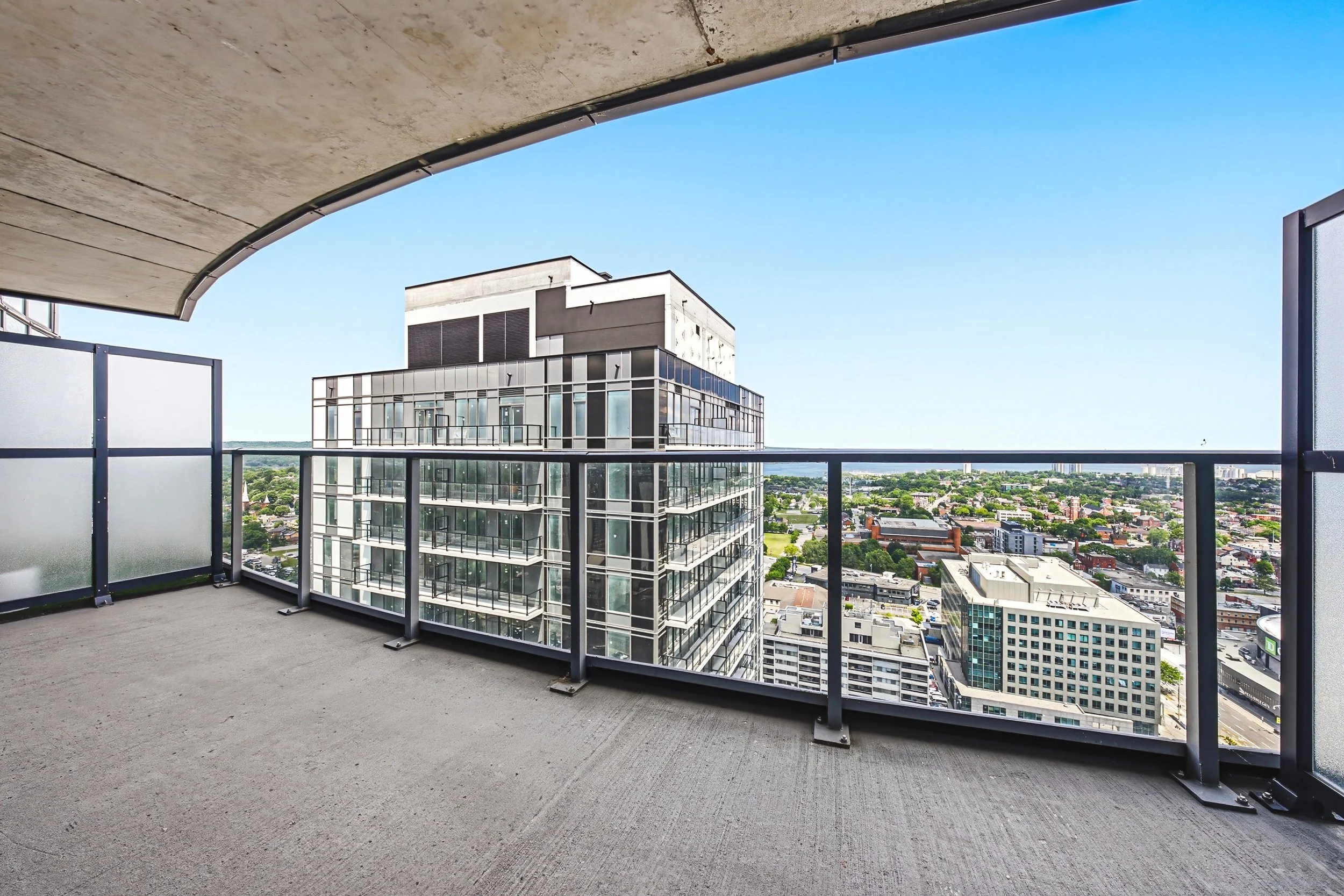 Balcony view of a modern high-rise building against a clear blue sky.