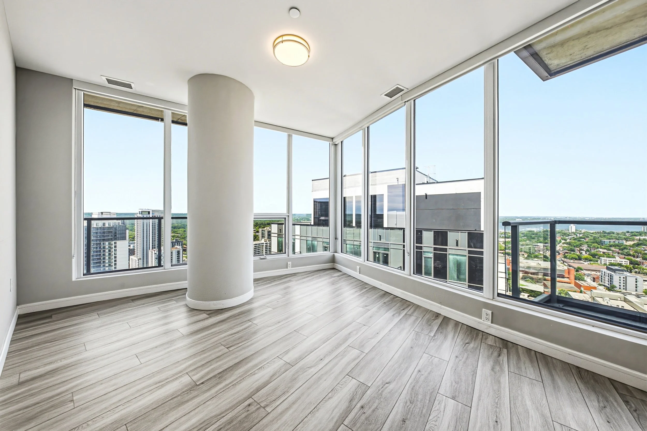 Empty modern apartment with large windows and cityscape views