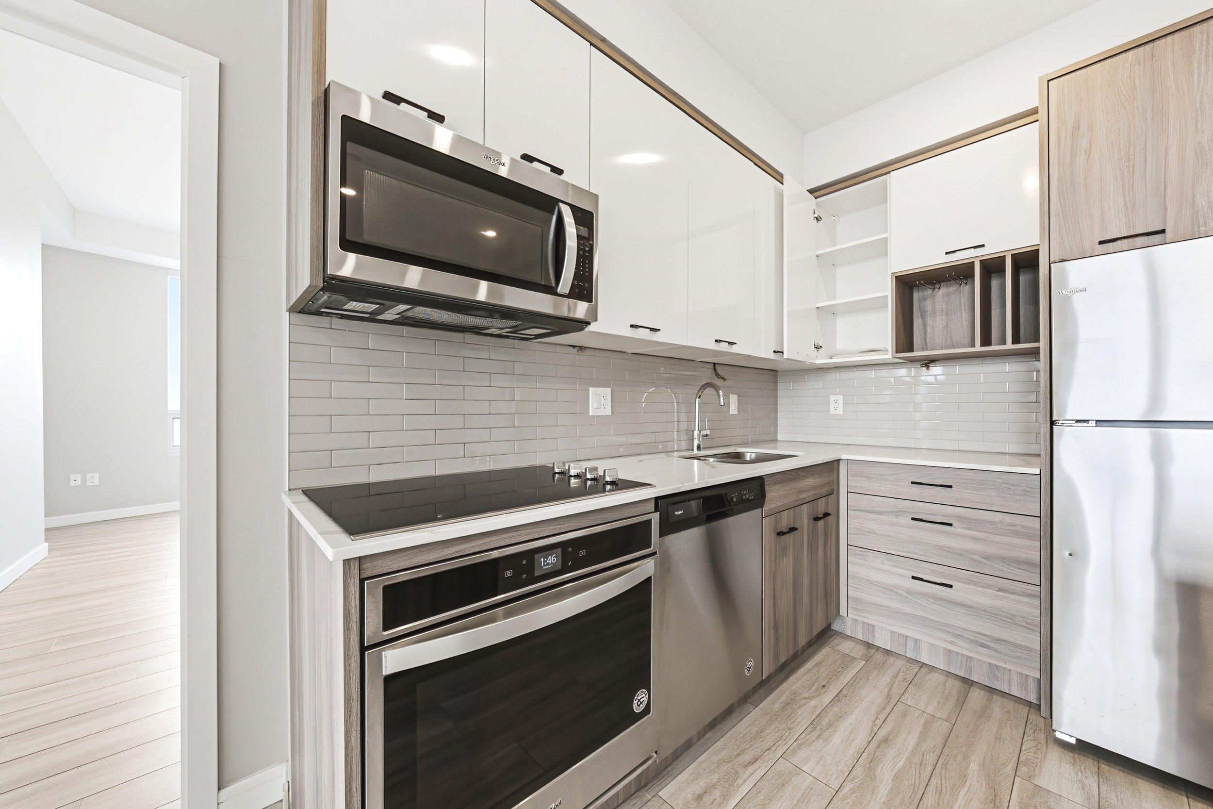 Modern kitchen with white cabinets, a stainless steel microwave, oven, range, and a white subway tile backsplash.
