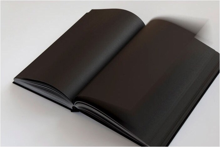 Open black photo album or portfolio with blank pages, resting on a white surface.
