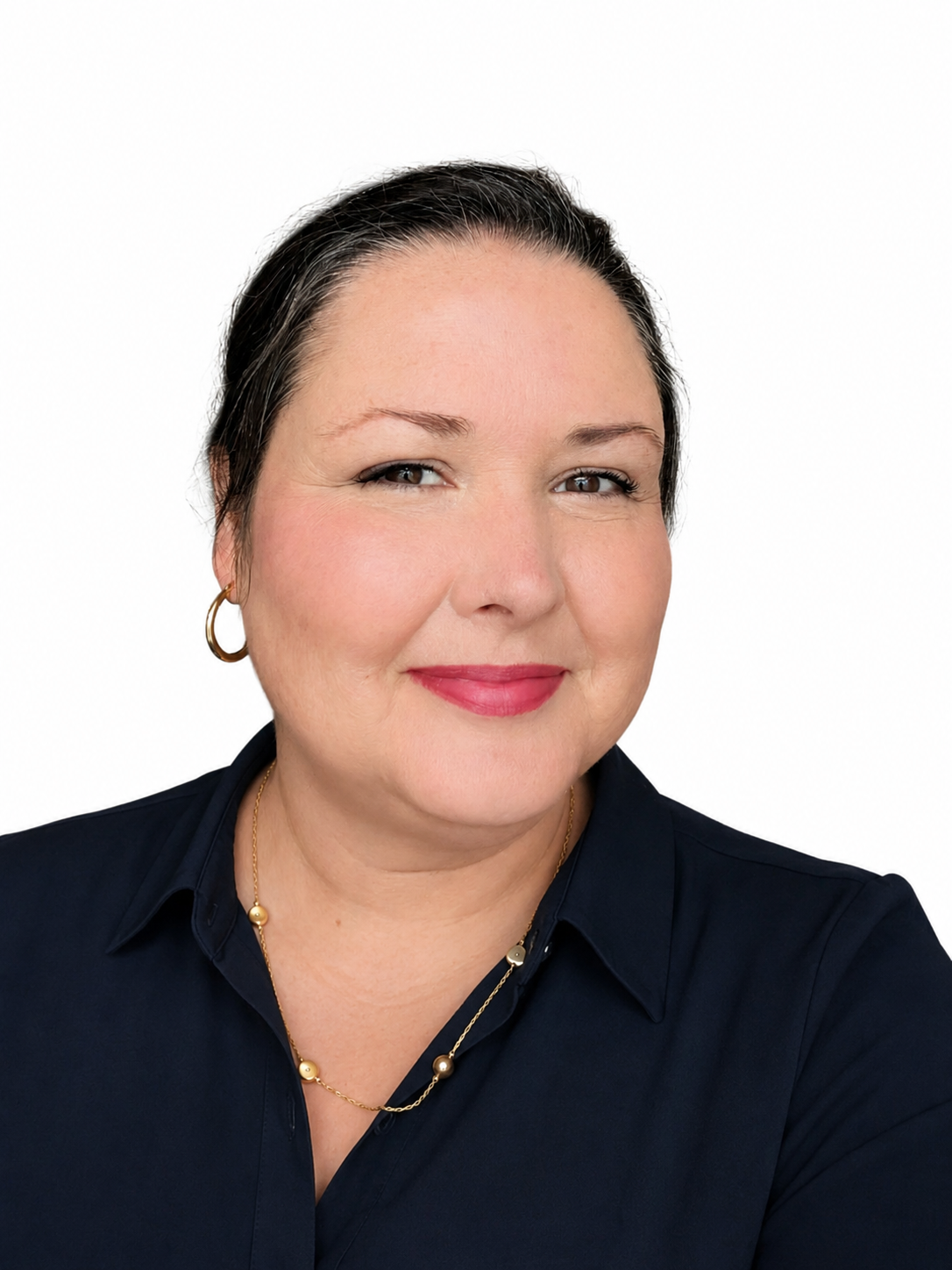 A woman with dark hair, wearing earrings and a necklace, smiling with a white background.