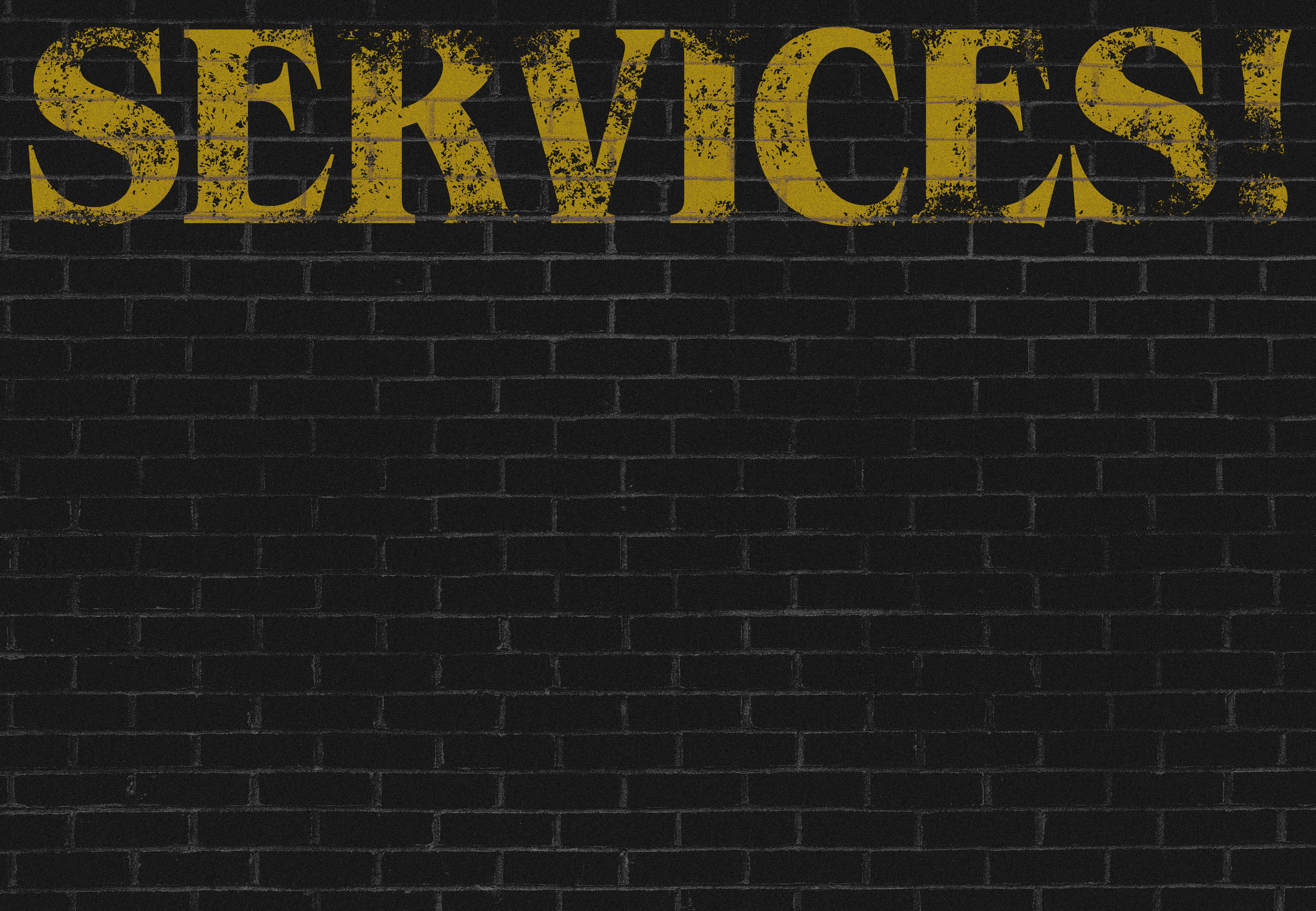 Yellow text that reads 'SERVICES' on a black brick wall.