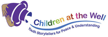 Logo for Children at the Well, featuring a colorful stylized well with a purple bucket and a rainbow arc of text reading 'Children at the Well' with a tagline 'Youth Storytellers for Peace & Understanding'.