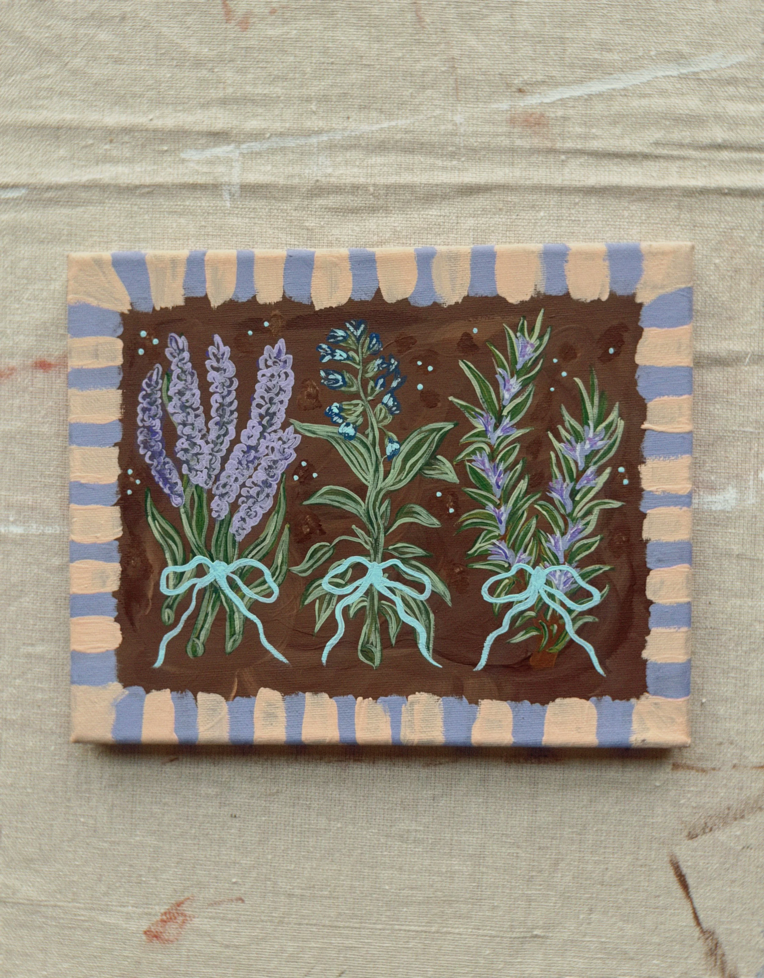 A painting of lavender and herbs on a fabric background with a border of alternating beige and lavender stripes.