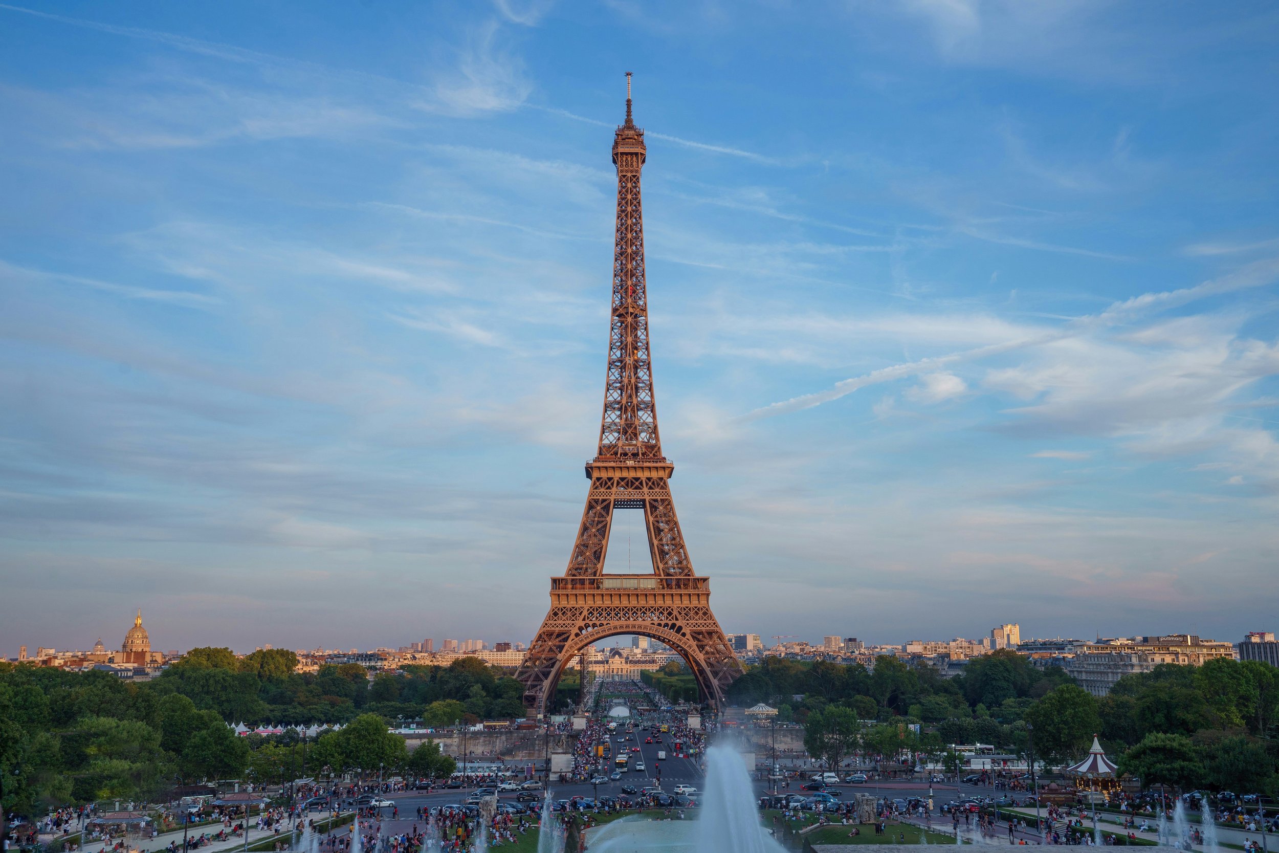 Wide view of the Eiffel Tower from Trocadéro at sunset with fountains