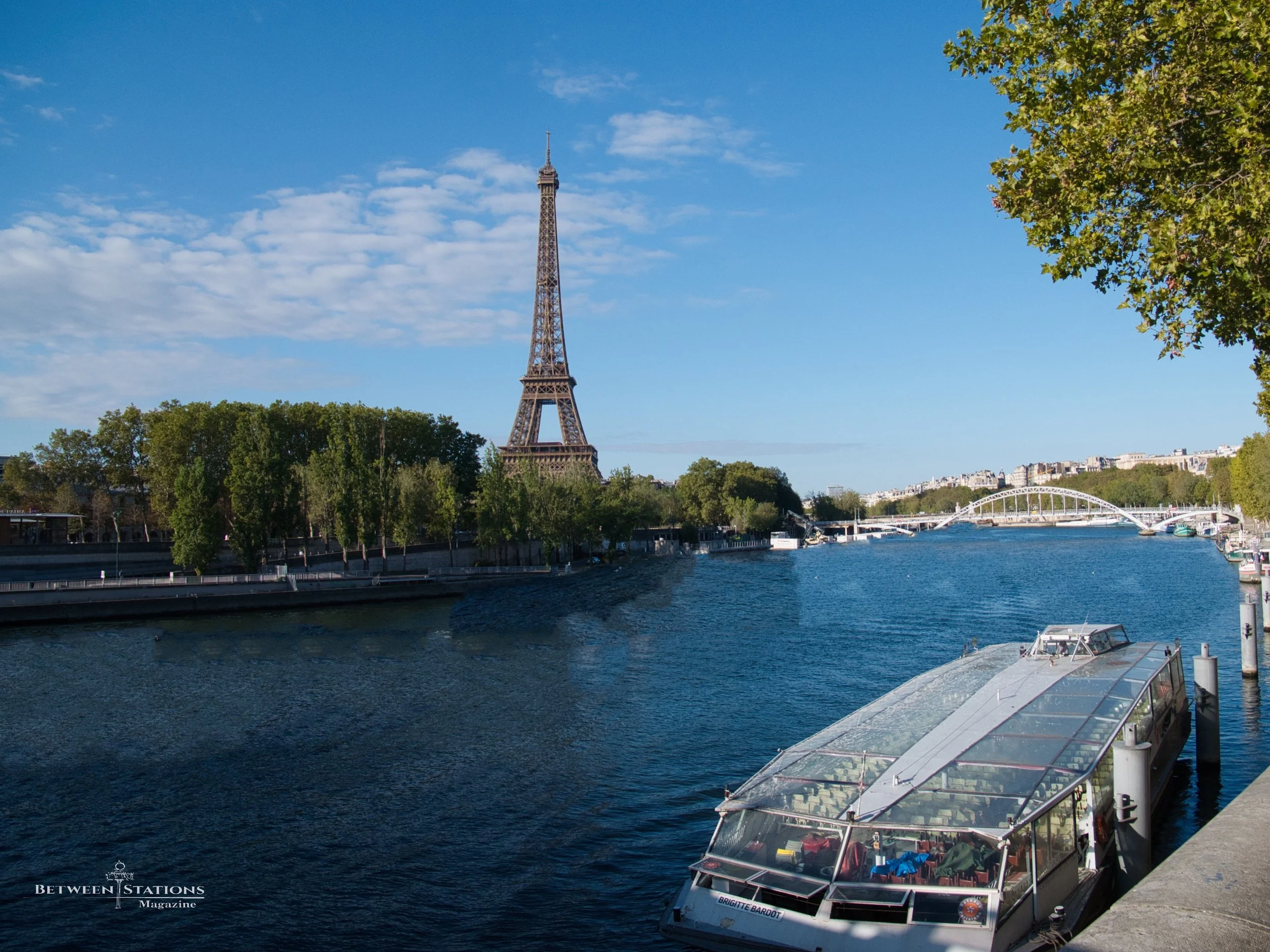 Eiffel Tower in the distance with a Seine river cruise boat in foreground