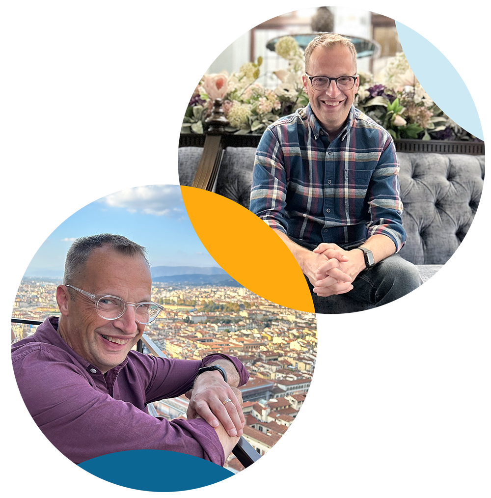 Two smiling men in casual clothing, one sitting indoors with a floral display behind him, the other outdoors overlooking a city skyline.