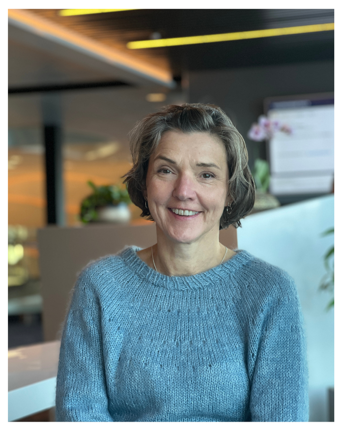 Chairman of the board GRO SKAAR-KNUDSEN wearing a blue sweater indoors.