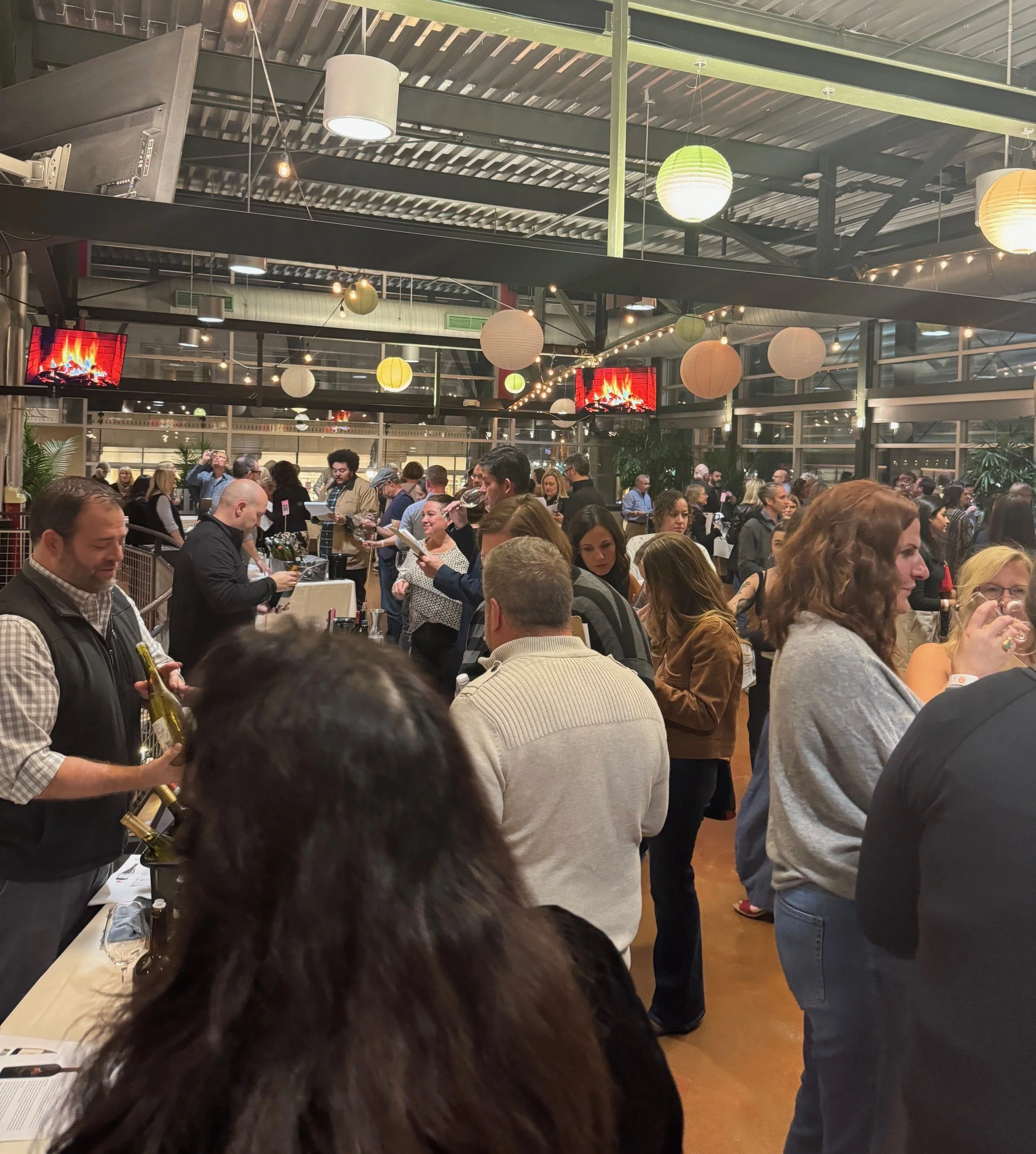 Crowd of people gathered at Thief Wine Shop and Bar's Grand Tasting at the Milwaukee Public Market in the Historic Third Ward.