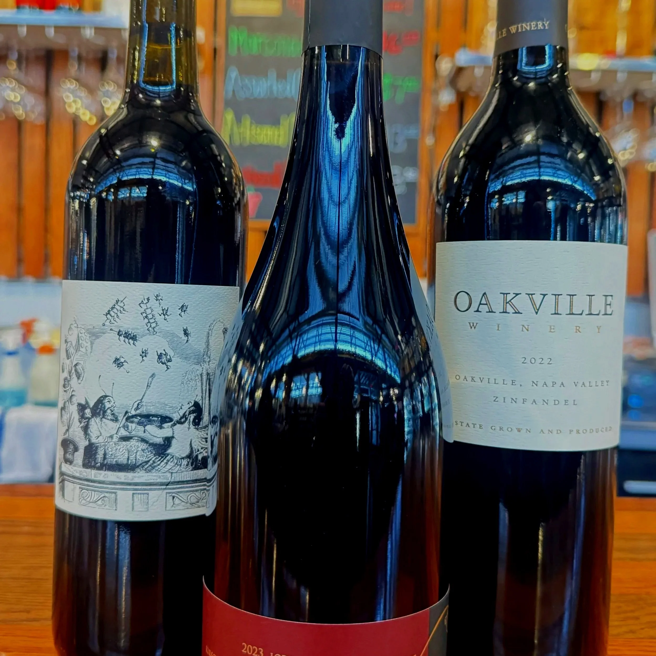 Three bottles of wine displayed on a wooden bar at Thief Wine at the Milwaukee Public Market in the Historic Third Ward of Milwaukee, Wisconsin