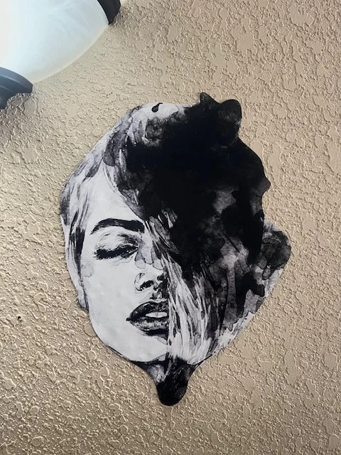 A balloon with a black and white artistic portrait of a woman's face with closed eyes and flowing hair.