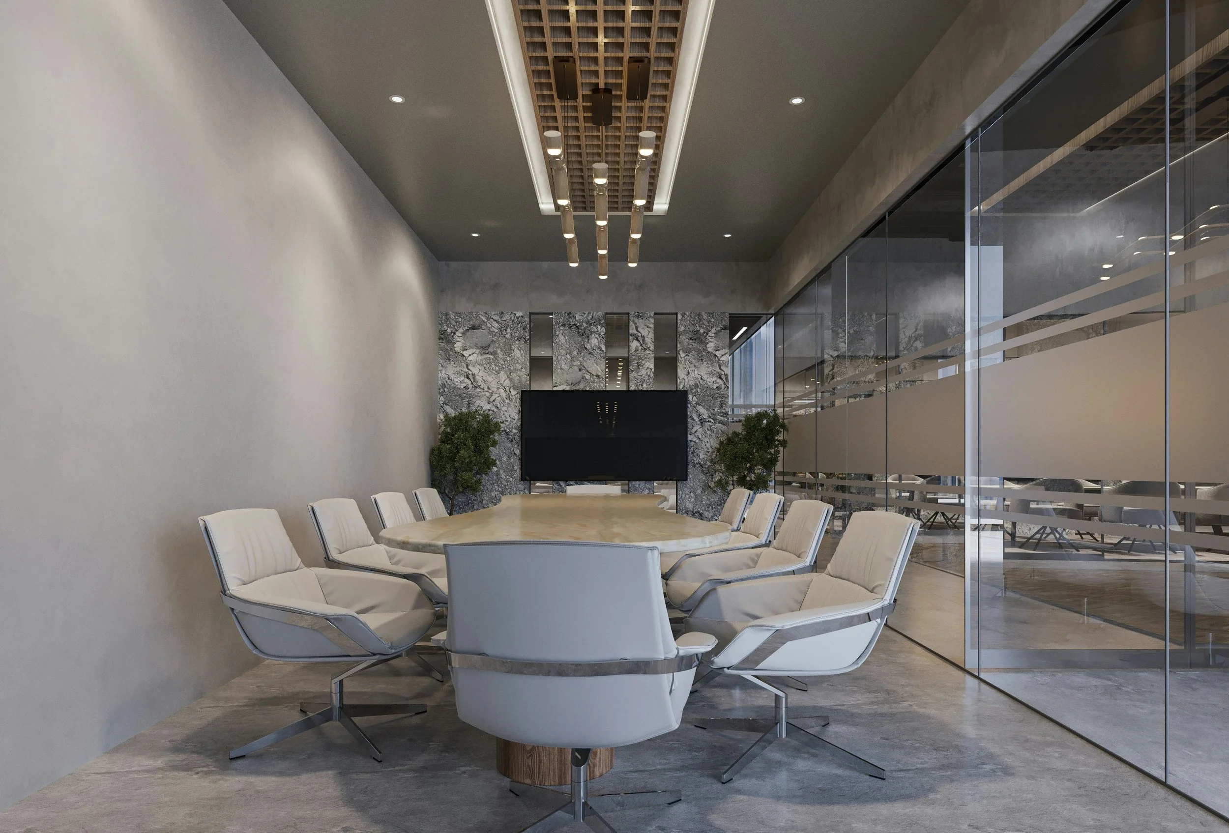 Modern conference room with a large wooden table surrounded by white chairs, marble wall behind a TV or monitor, and large glass wall on the right with a view of an adjacent space, decorative plants on either side of the TV, and a ceiling feature with hanging lights.