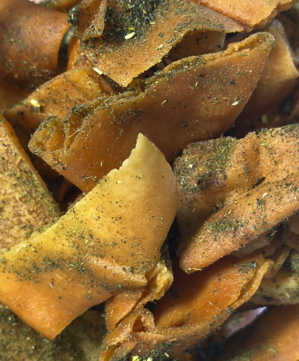 Close-up of seasoned, crispy lotus root chips seasoned with herbs and spices.