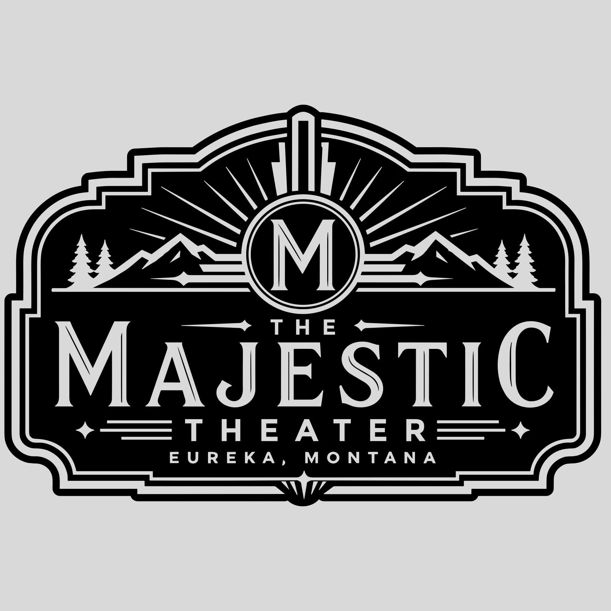 Black and white logo for the MaJestic Theatre, featuring mountain peaks, trees, a sunburst, and text indicating it is located in Eureka, Montana.