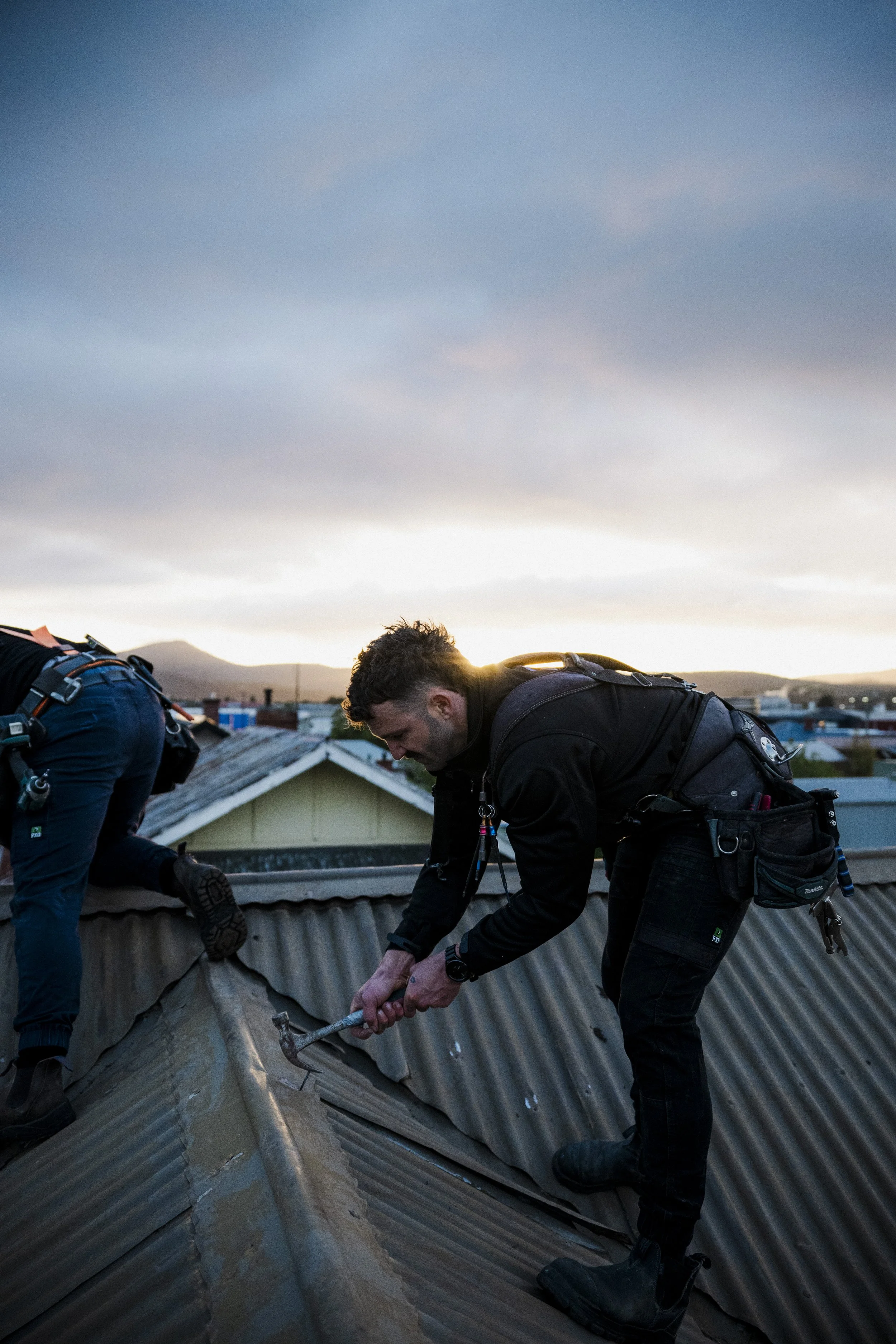 Oranssi technician working on a roof project