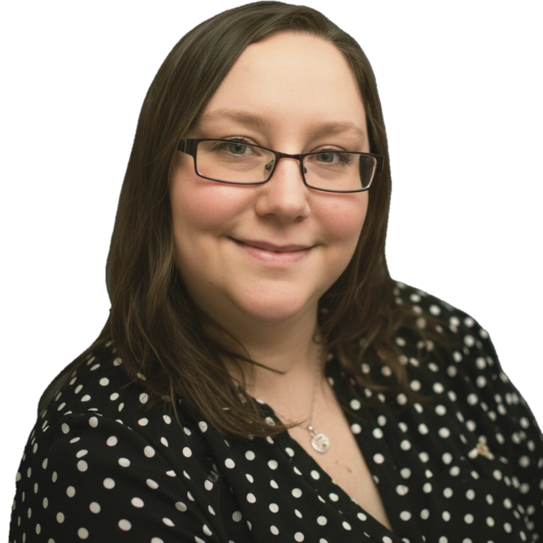 A woman with shoulder-length brown hair wearing glasses and a black blouse with white polka dots, smiling at the camera.