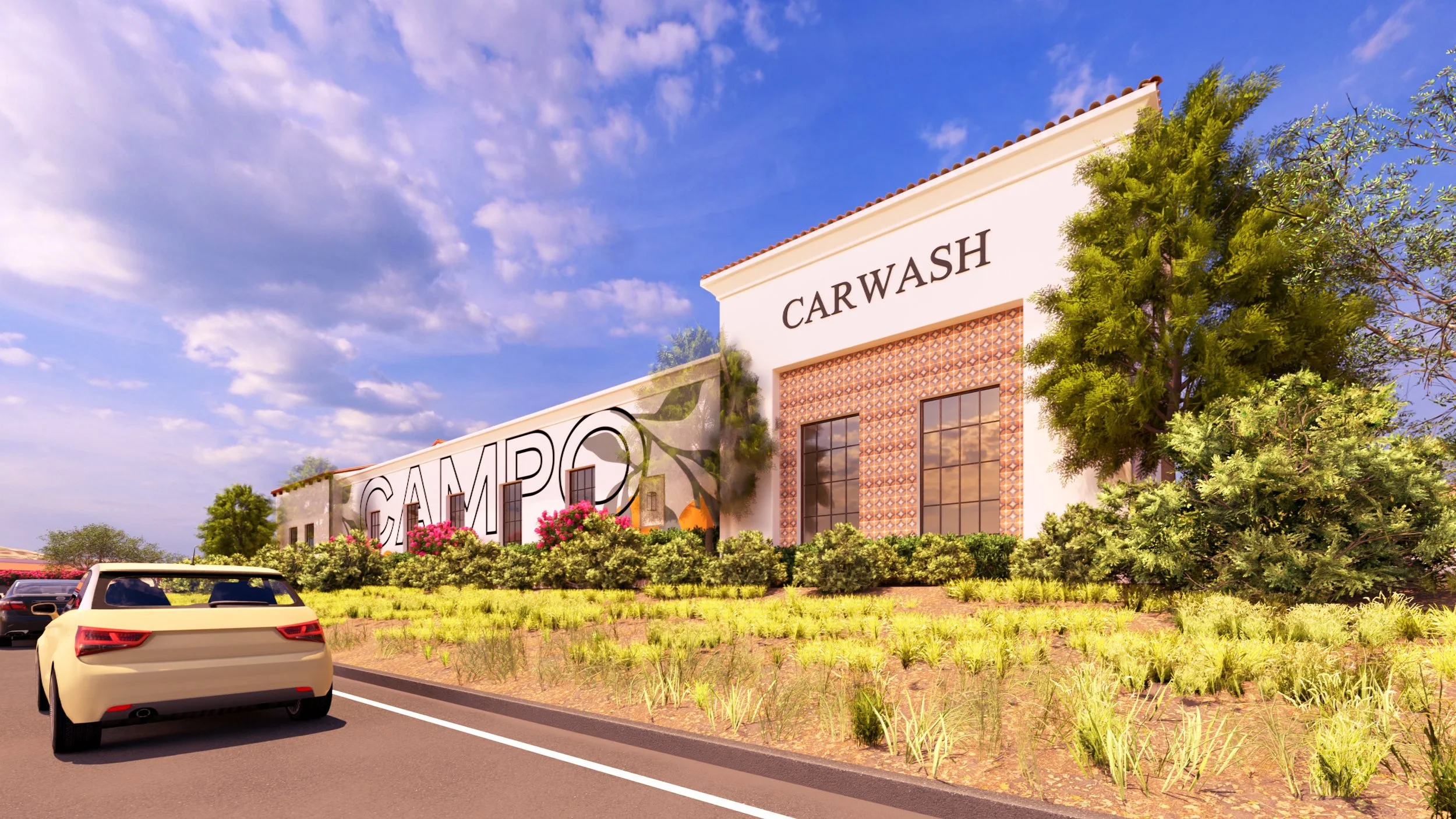 The image shows a car wash building with a sign that reads 'CAR WASH' and part of the word 'GAMERO,' a parking lot with cars, and landscaping with green bushes and trees under a partly cloudy blue sky.