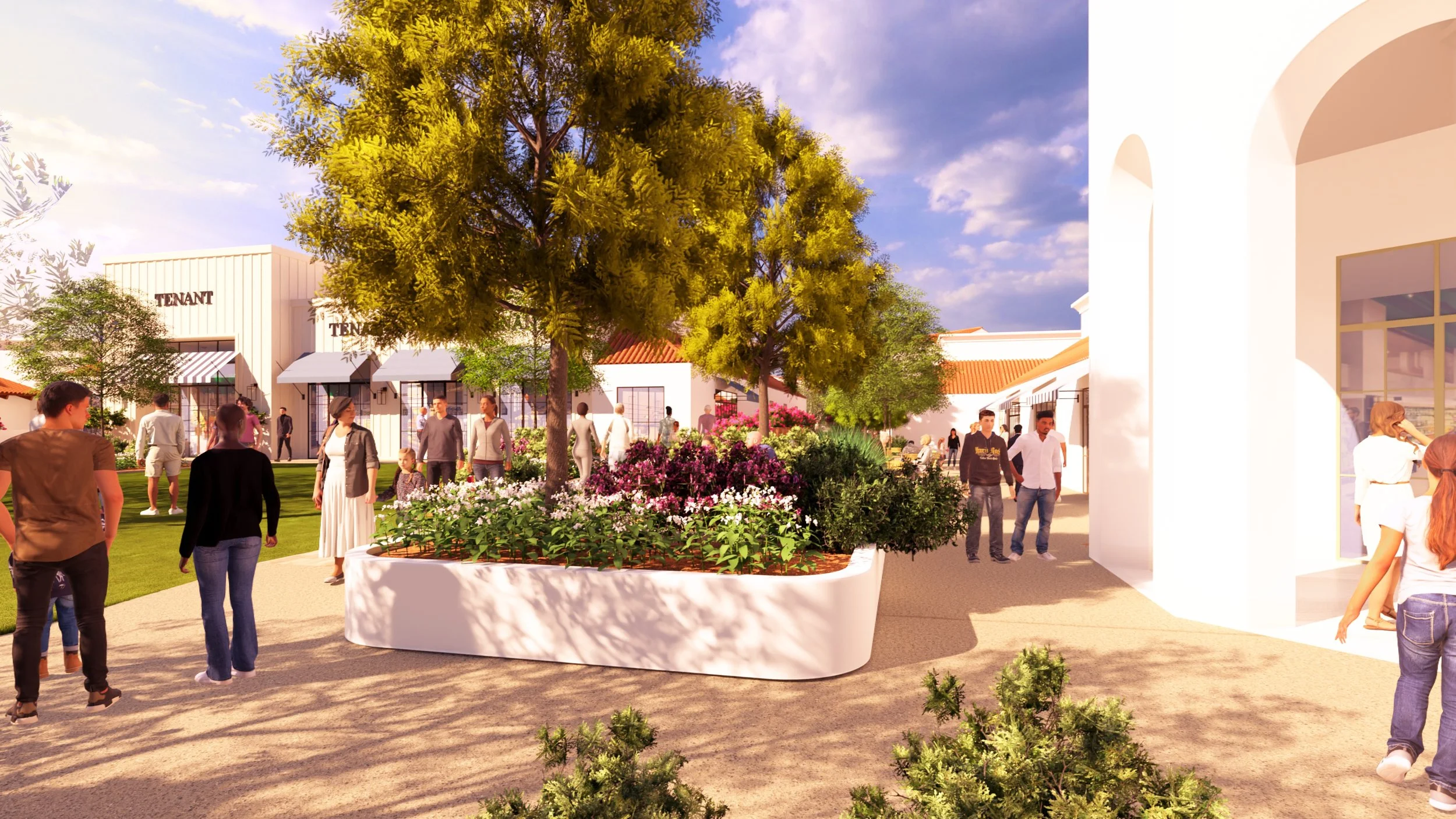 People walking and socializing in a landscaped outdoor shopping area with trees, flowers, and white buildings.