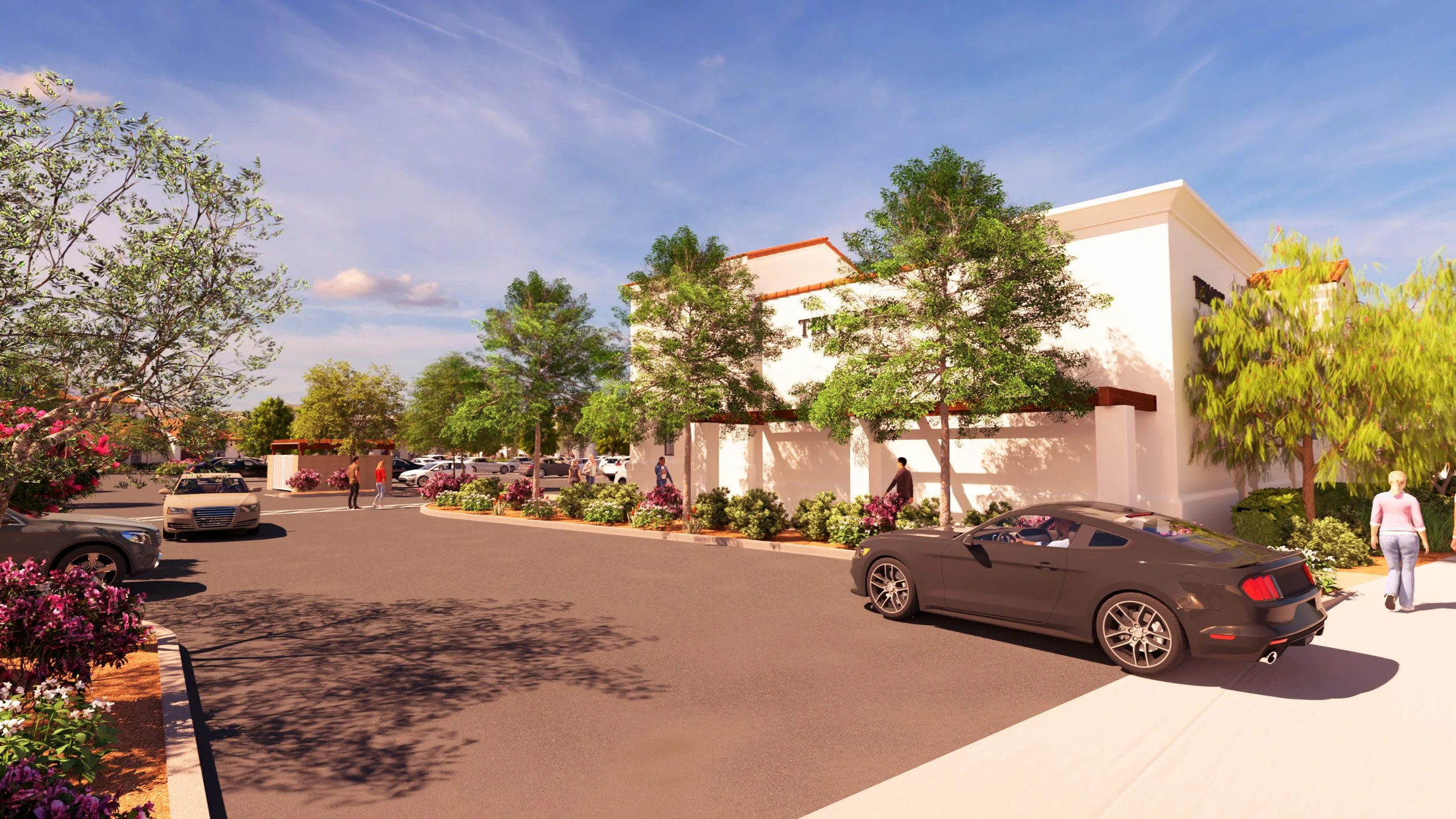 An outdoor shopping center parking lot with cars, trees, and people walking near a white building under a blue sky.