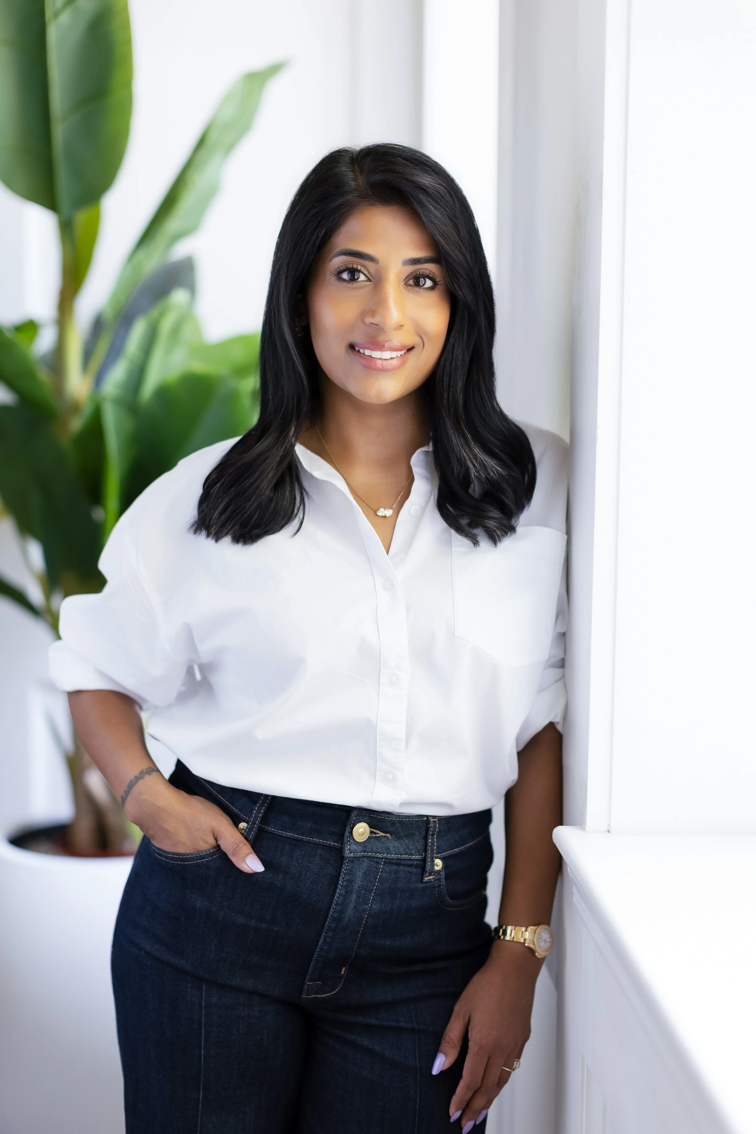 Shradha Lukka, founder of Lukka Collective, smiling in a modern interior design studio, specializing in kitchen renovations, bathroom design, and residential interiors in New Jersey and New York City.