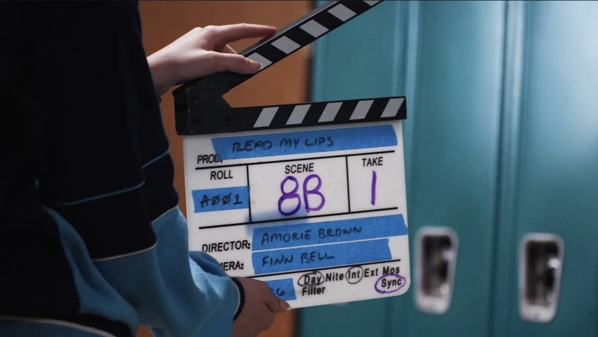 Director's slate on a film set showing scene 8B, take 1, directed by Amorie Brown, cinematographer Finn Bell, with notes about lighting and filters.