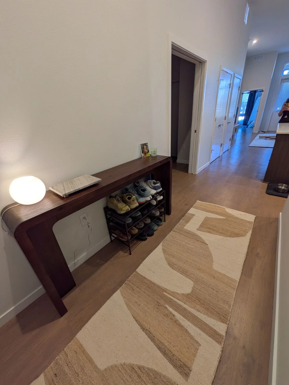 AFTER…It wasn't only the living room that was an echo chamber. Client used to walk into a cold, non-functioning entry. Now he has a place for essentials and the runner invites guests into the home.