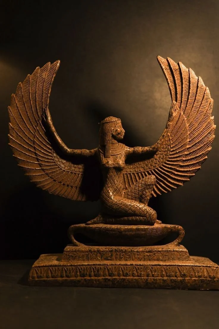 Ancient sculpture of a mythological creature with a human upper body and a snake lower body, featuring large, elaborate wings spread wide, set against a dark background.
