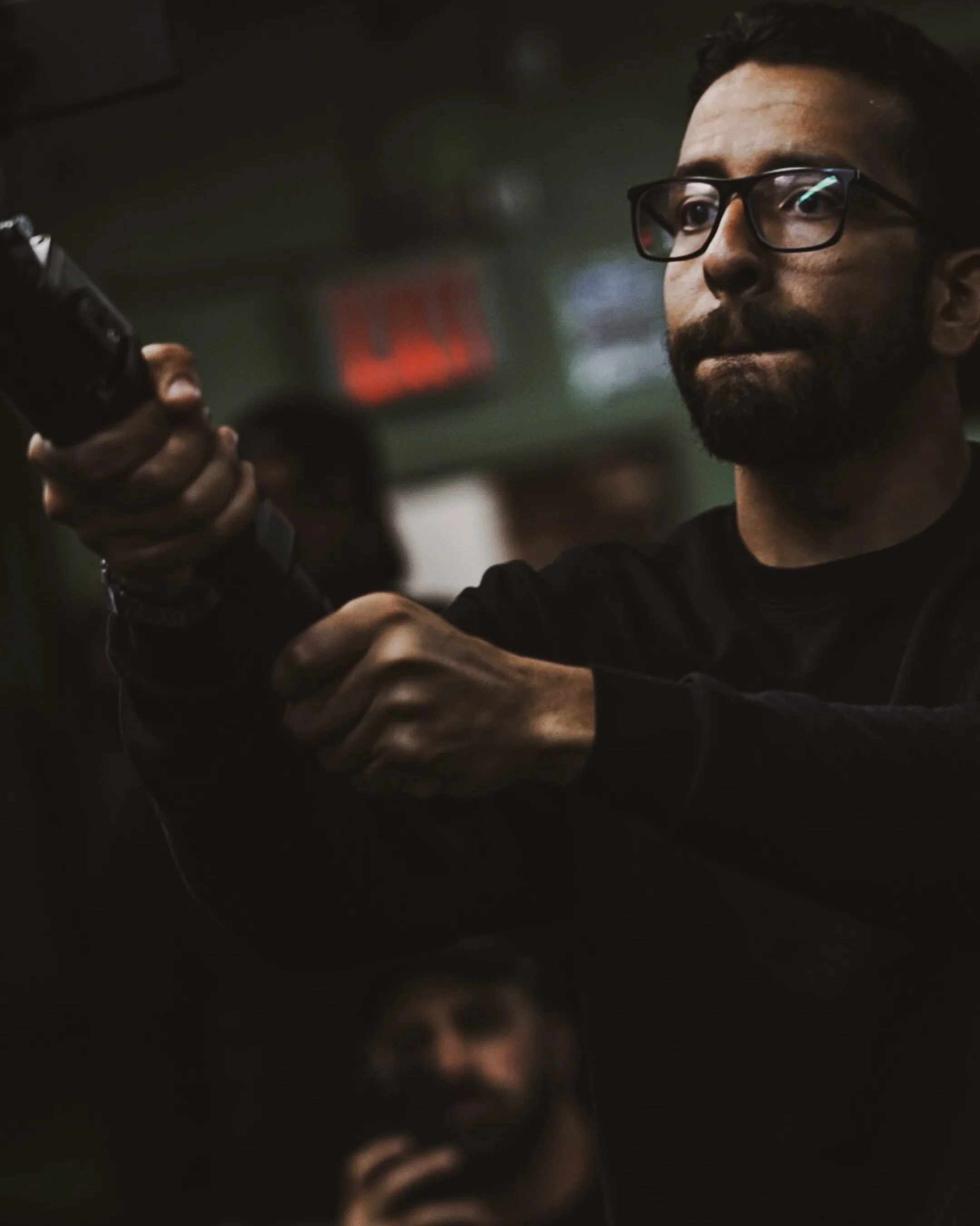 A photo Marc Andrew DeJesus actively filming for metamorphoses fitness gym mid concentration, lips pursed.
