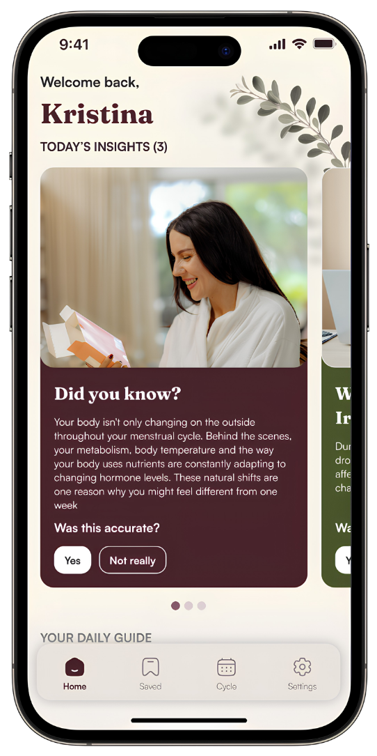 A woman with dark hair smiling while reading a booklet on a tablet in a well-lit room with neutral tones.