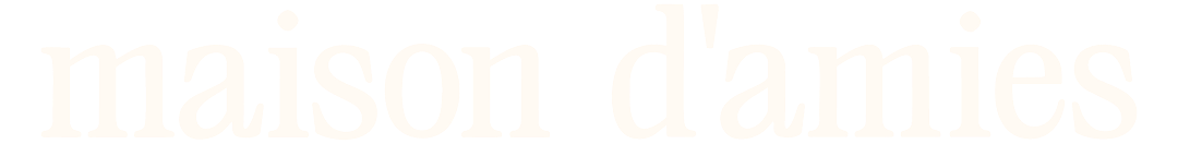 The logo for Maison d'amis, a French phrase meaning 'house of friends,' is displayed with white text on a black background.