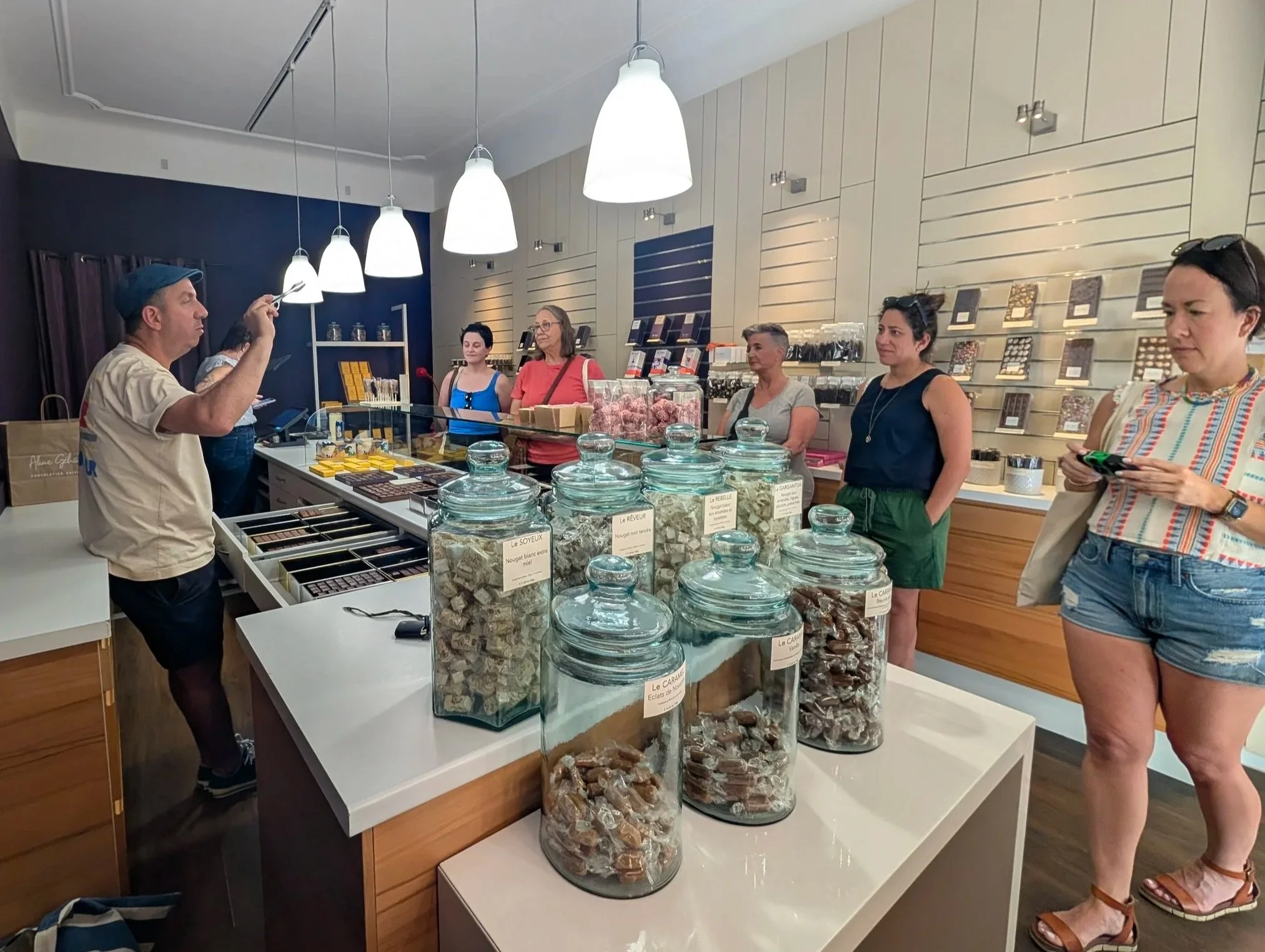 Stephanie and retreat guests with guide Julien inside a closed chocolate shop in Avignon, France