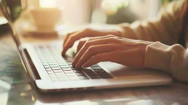 Person typing on a laptop keyboard in a well-lit room.