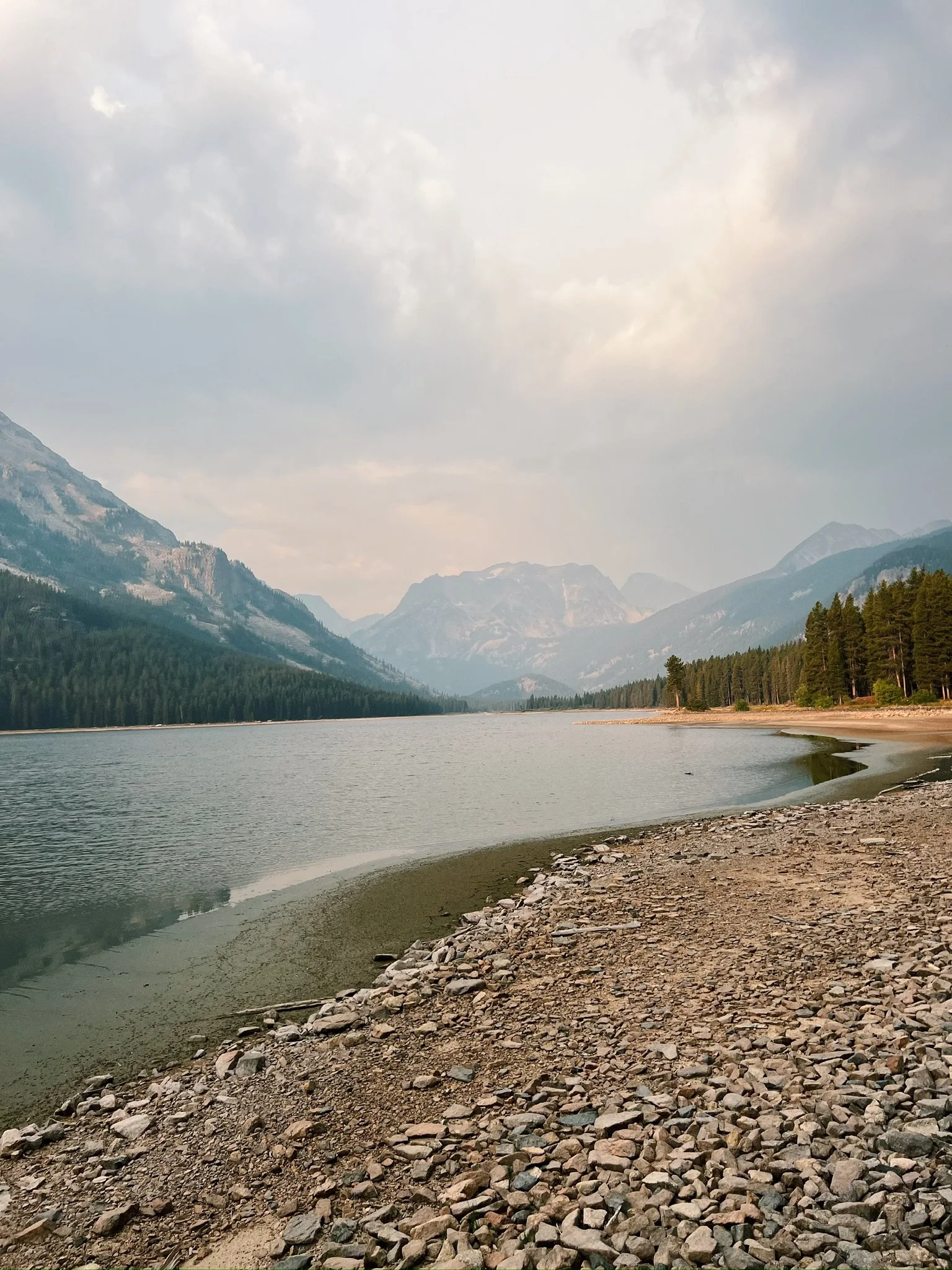Still alpine lake reflecting surrounding mountain peaks in Montana