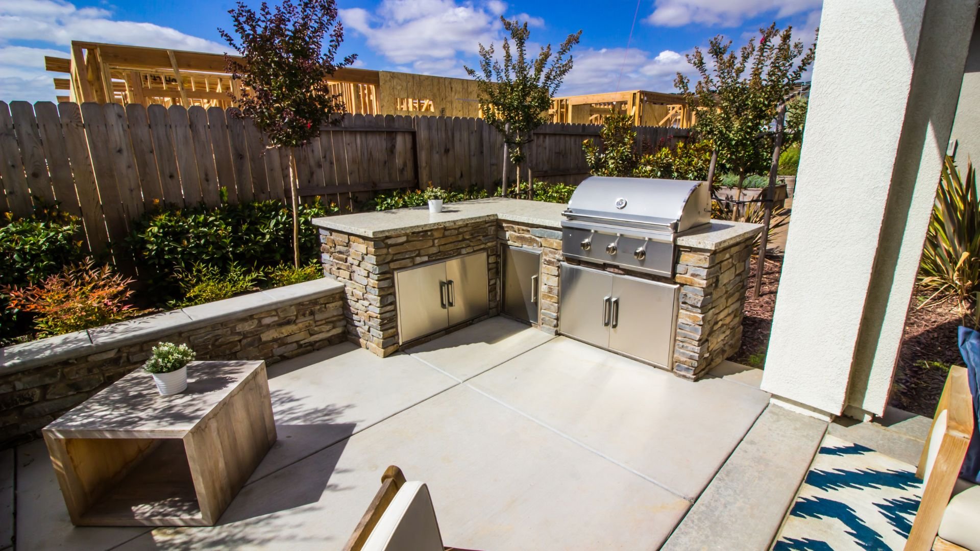 Outdoor patio area featuring a built-in grill with stone and stainless steel