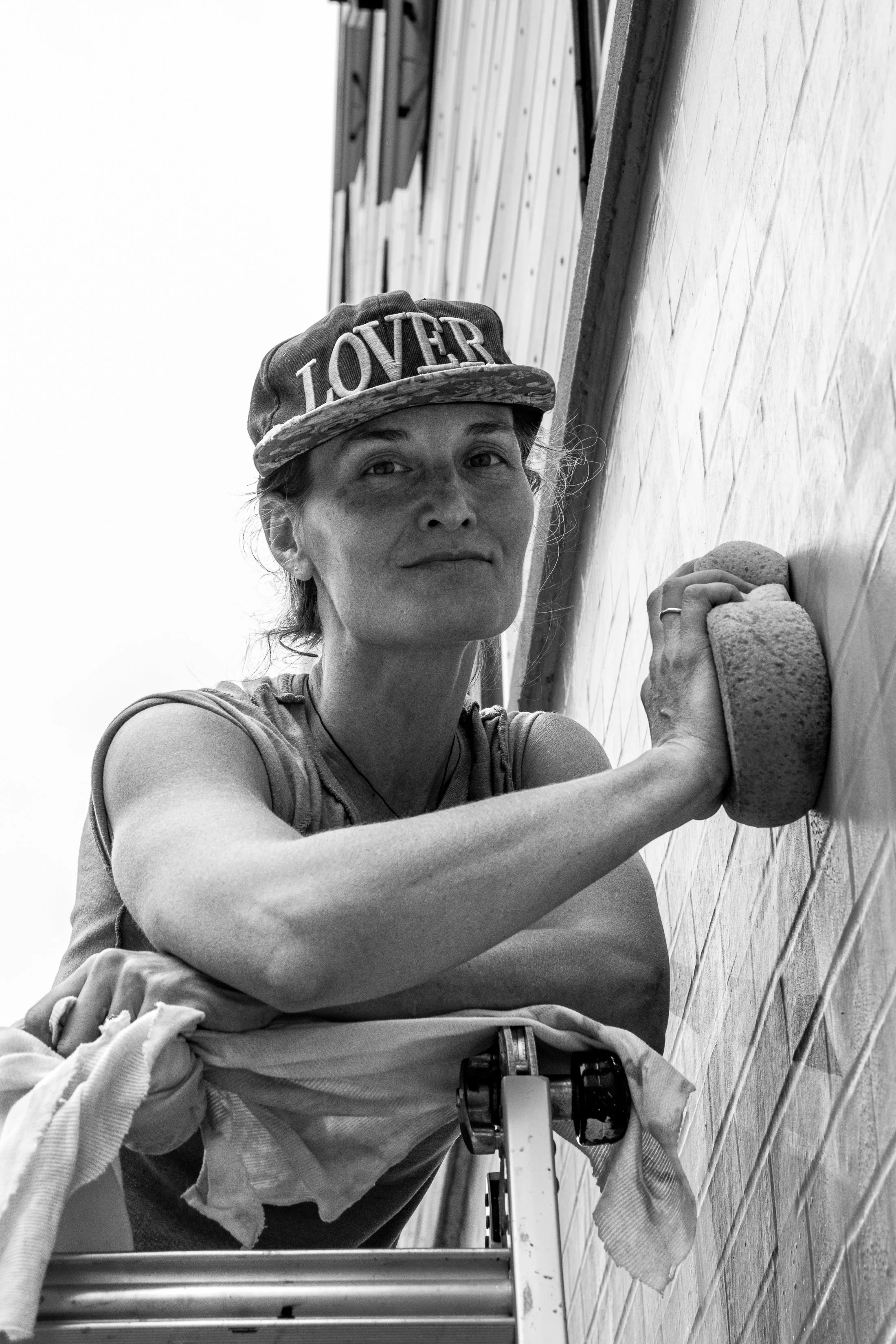 Alison cleans graffiti off of her mural in North Philadelphia in Oct. 2024