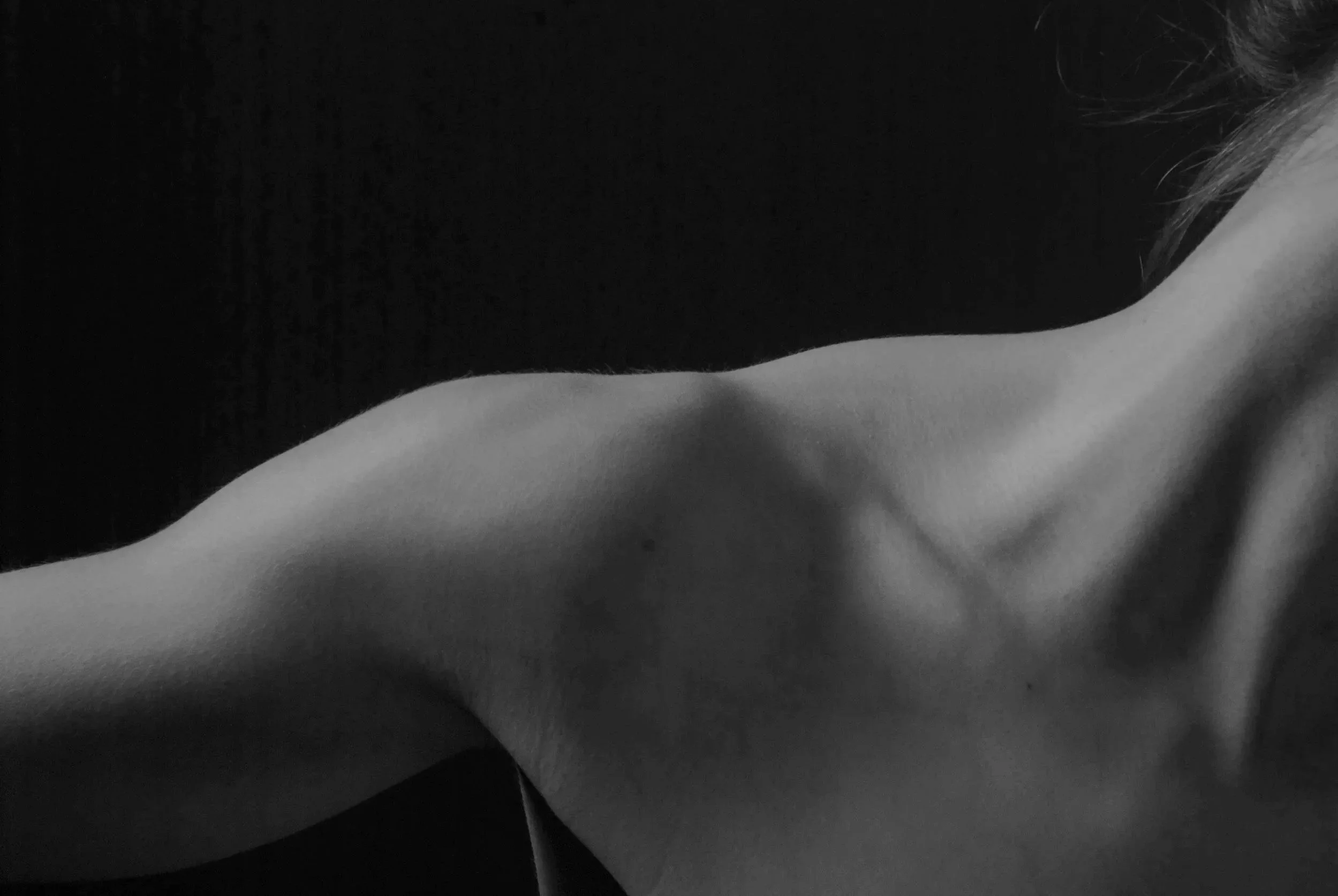 Close-up of a person's shoulder and neck area, black-and-white photograph.
