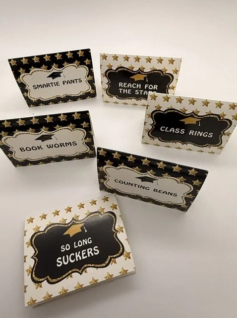 Six decorative name cards with star and ribbon designs, each with a different playful label, on a white surface.