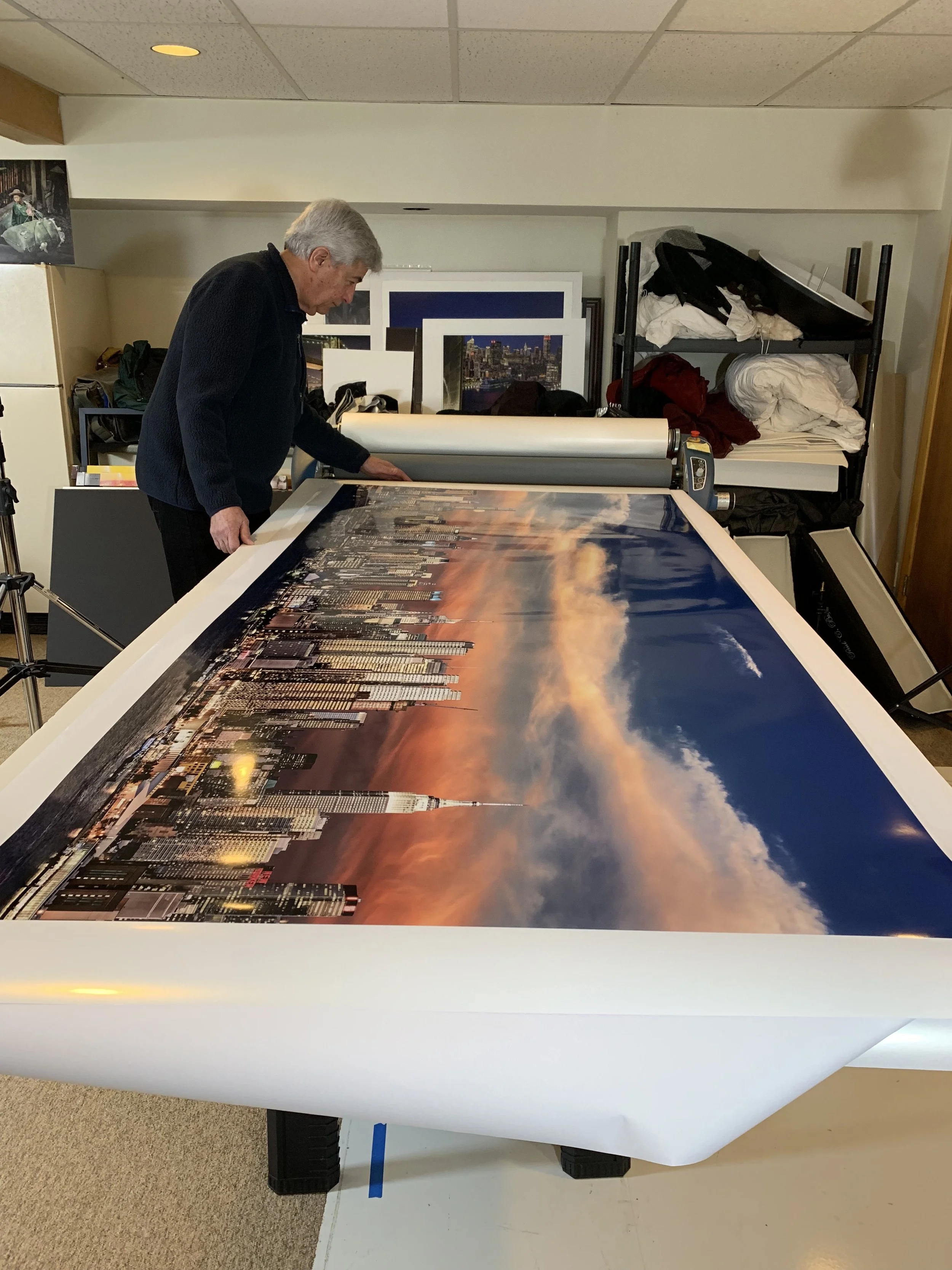 Malcolm Kahn inspecting a large print in his studio before face mounting.