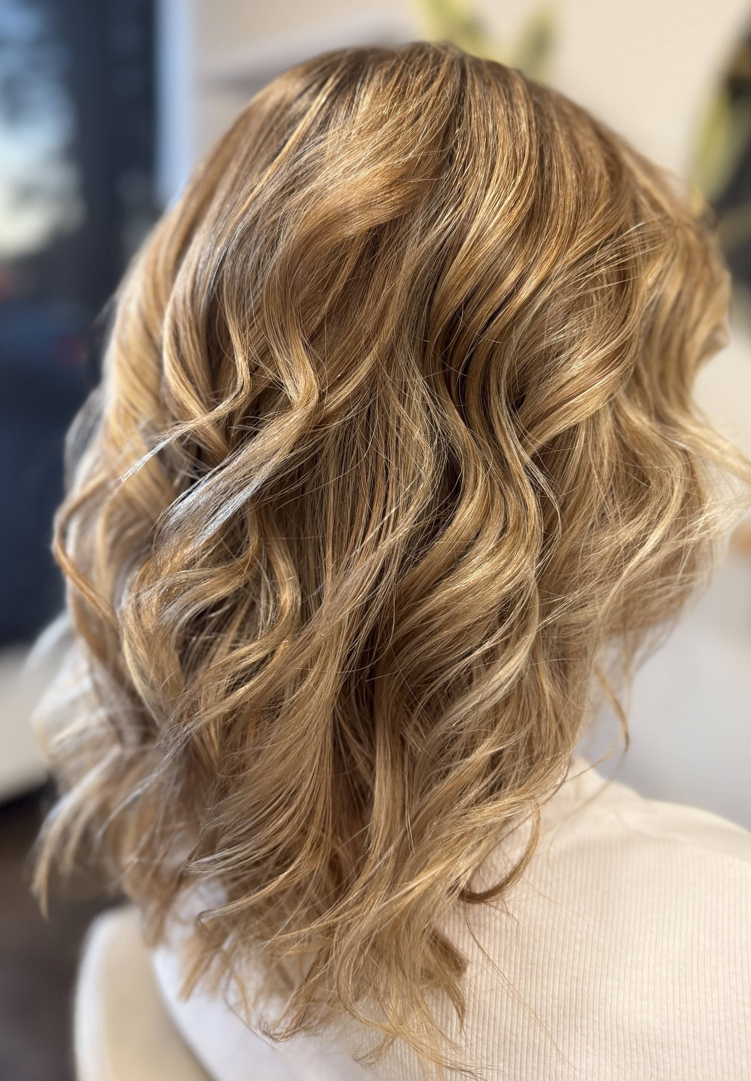 Close-up view of blonde hair styled in loose waves.