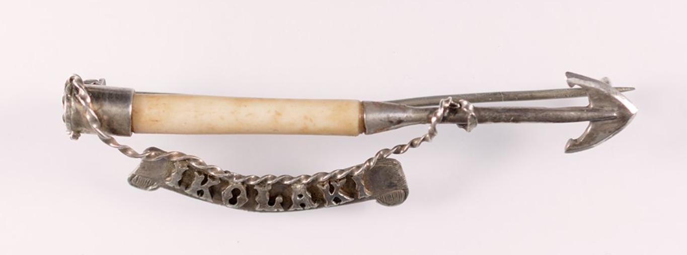 A vintage pipe with an individual arrow-shaped metal tip and a decorative chain for hanging. Akaroa Museum Collection