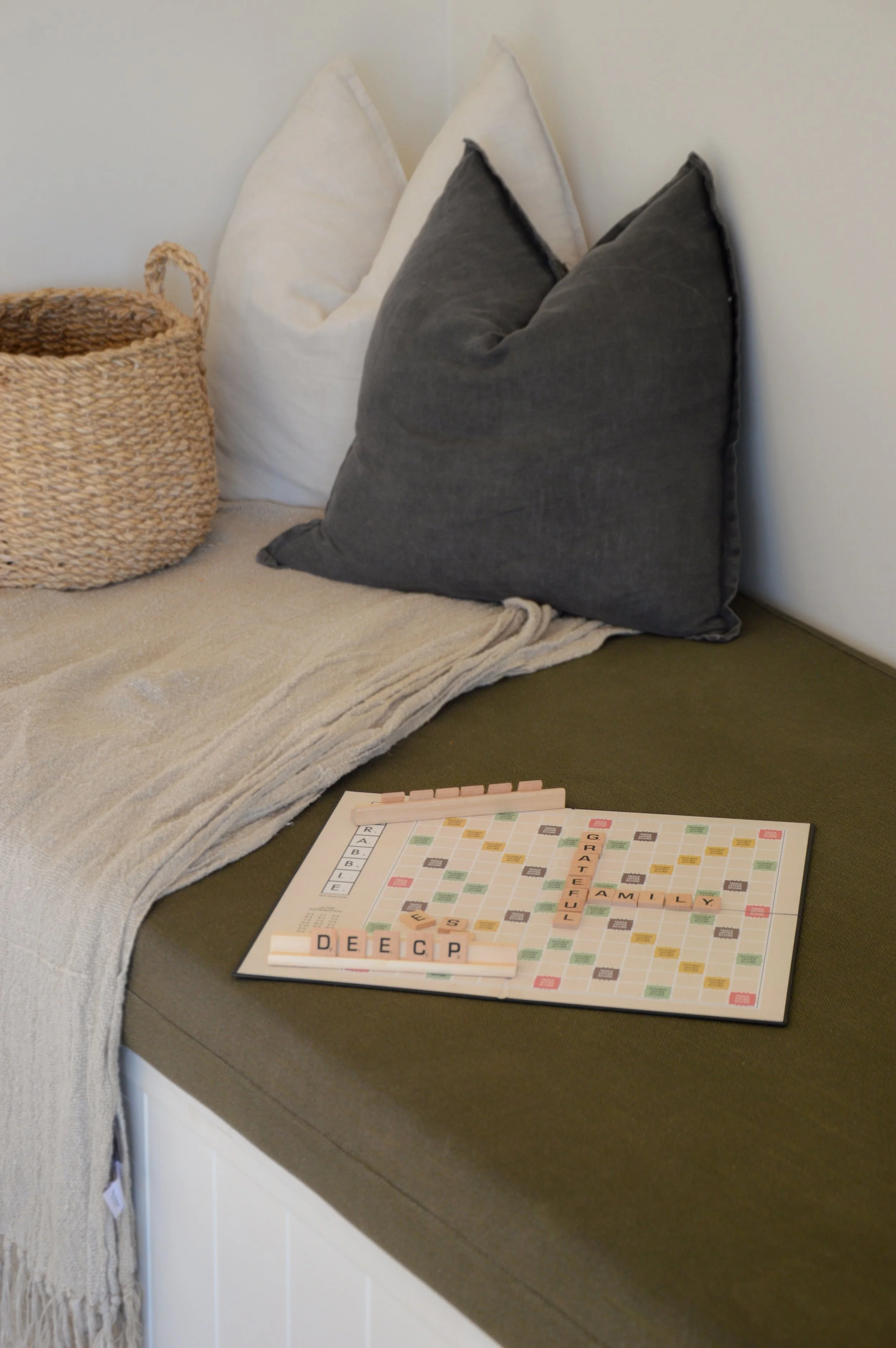 Scrabble board sitting on a olive green bench seat