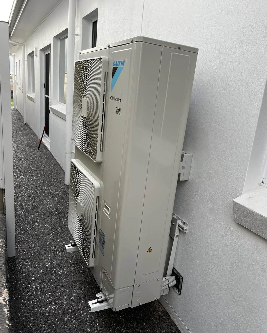 Daikin inverter outdoor air-conditioning unit mounted on the exterior wall of a building