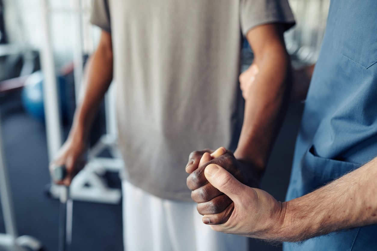 Two people shaking hands in a gym or fitness center.