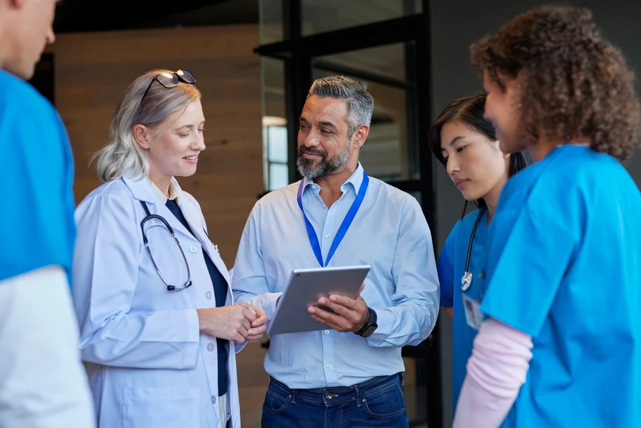 Group of healthcare professionals, including doctors and nurses, having a discussion in a hospital or medical facility.