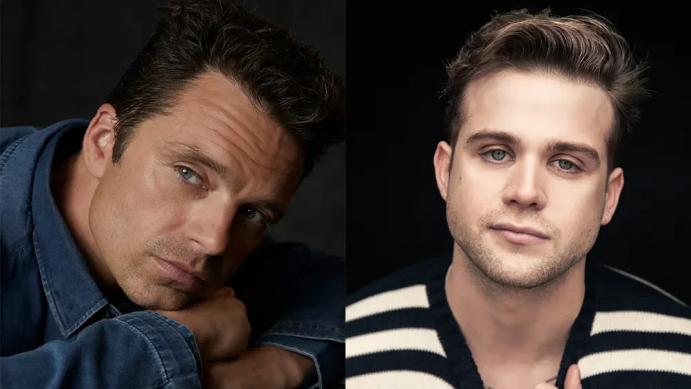 Close-up of two men with fair skin and blue eyes against a dark background, one on the left wearing a denim shirt and resting his chin on his arm, and the other on the right wearing a black and white striped sweater, both looking at the camera.