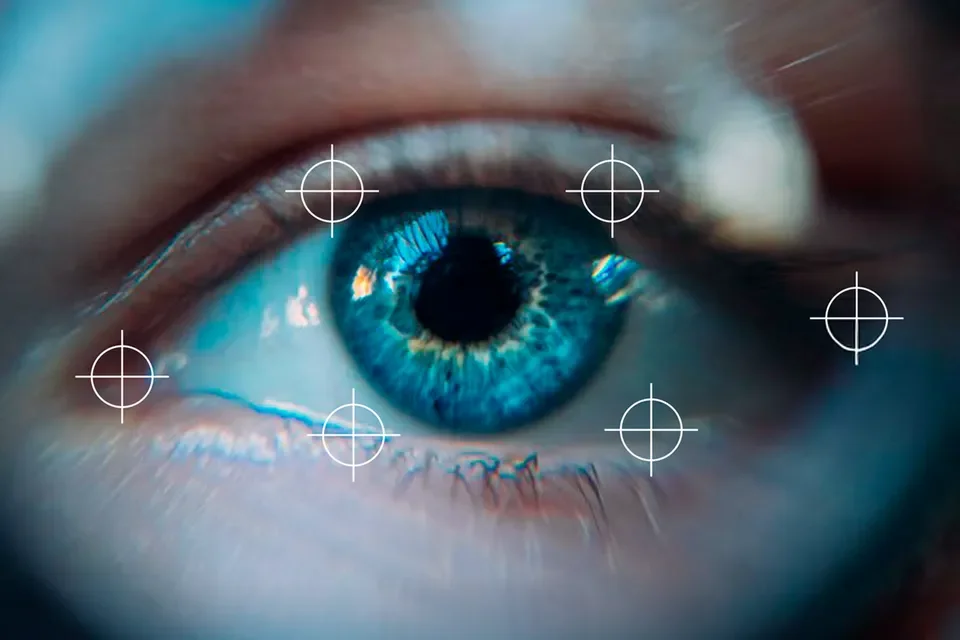 Close-up of a human eye with a blue iris, surrounded by white and brown skin, with digital crosshair targeting overlays.