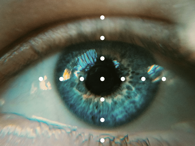 Close-up of a human eye with a blue iris, showing reflections and detailed textures, along with overlayed white dots indicating alignment points.
